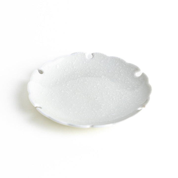 Ceramic sauce dishes with scalloped edges, available in black and white.