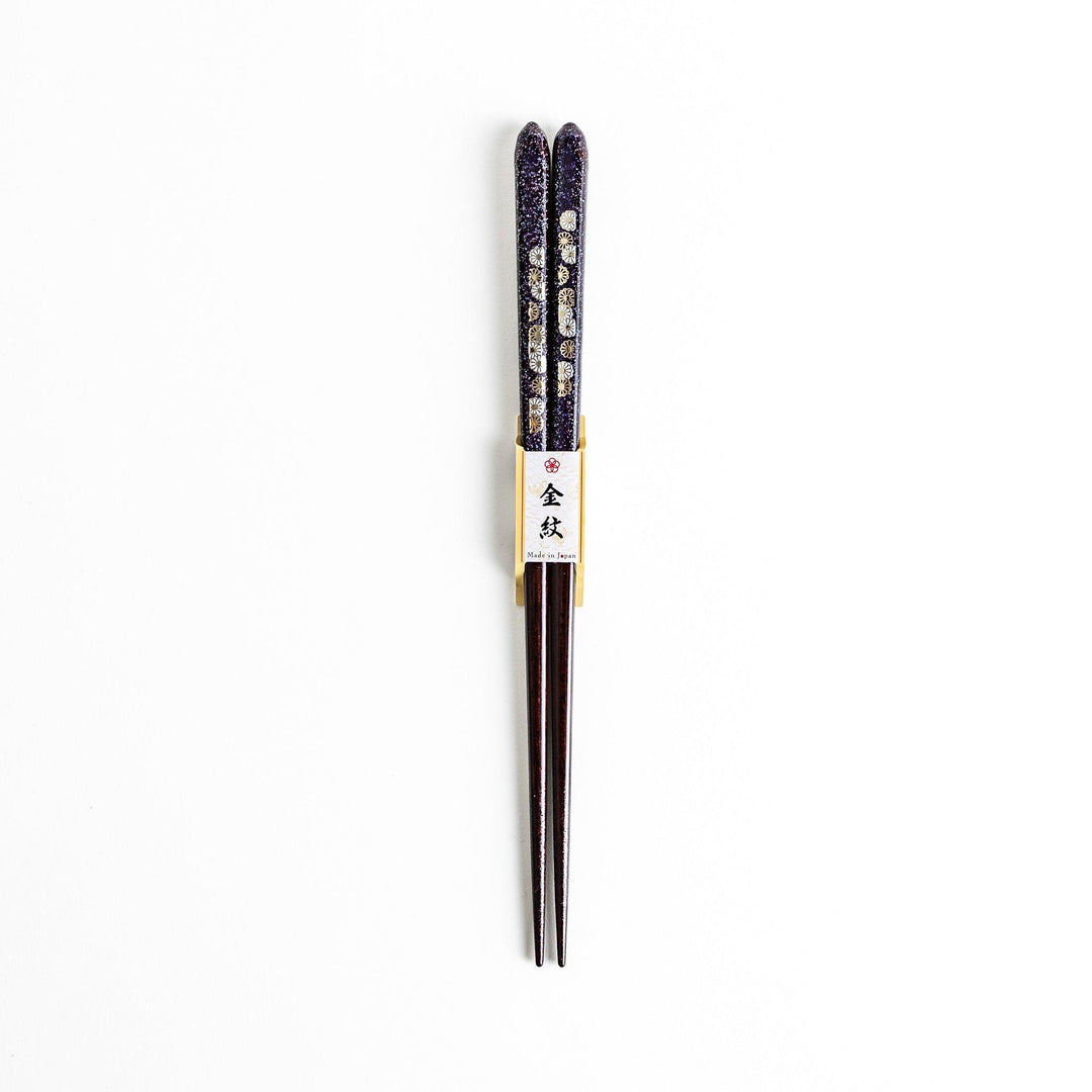 Two pairs of chopsticks, one in deep purple and the other in red, each decorated with subtle gold accents and a speckled finish.