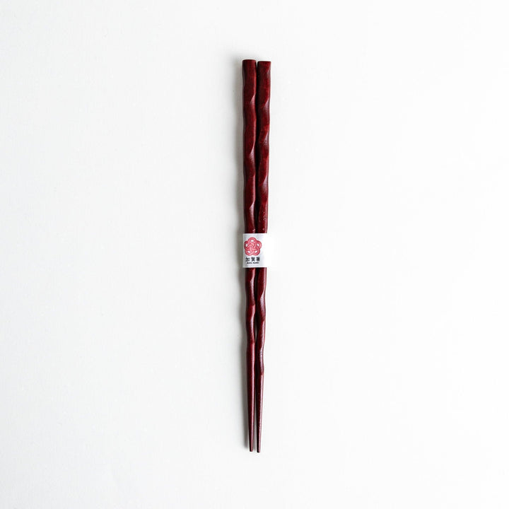 Lacquered chopsticks pair with carved textured surface for elegant grip available in black or red.