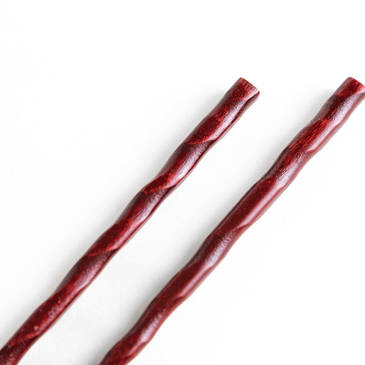 Lacquered chopsticks pair with carved textured surface for elegant grip available in black or red.