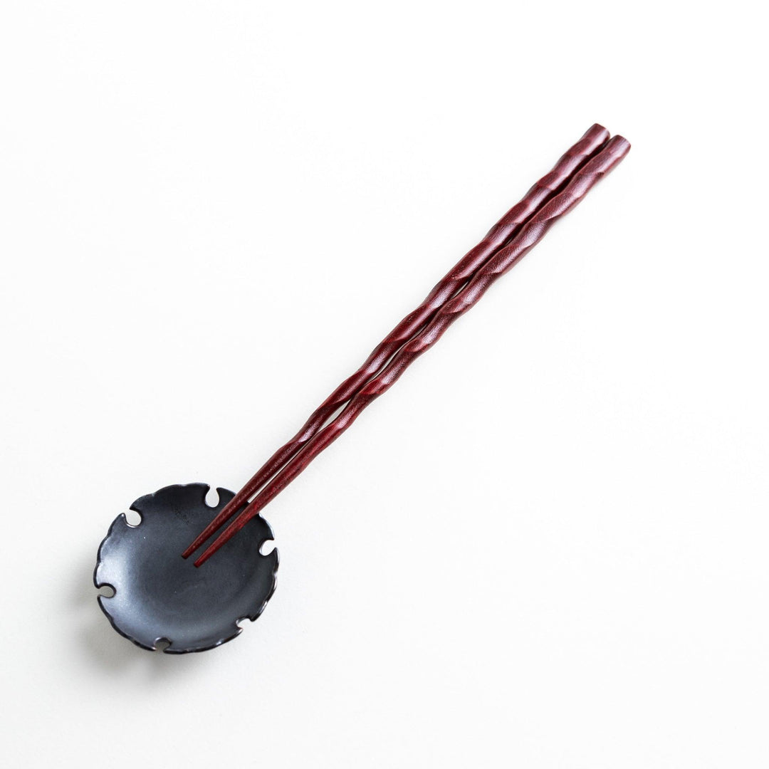 Lacquered chopsticks pair with carved textured surface for elegant grip available in black or red.