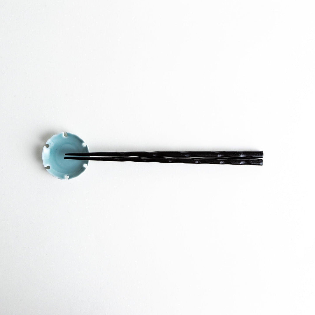 Lacquered chopsticks pair with carved textured surface for elegant grip available in black or red.