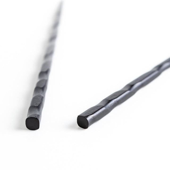 Lacquered chopsticks pair with carved textured surface for elegant grip available in black or red.