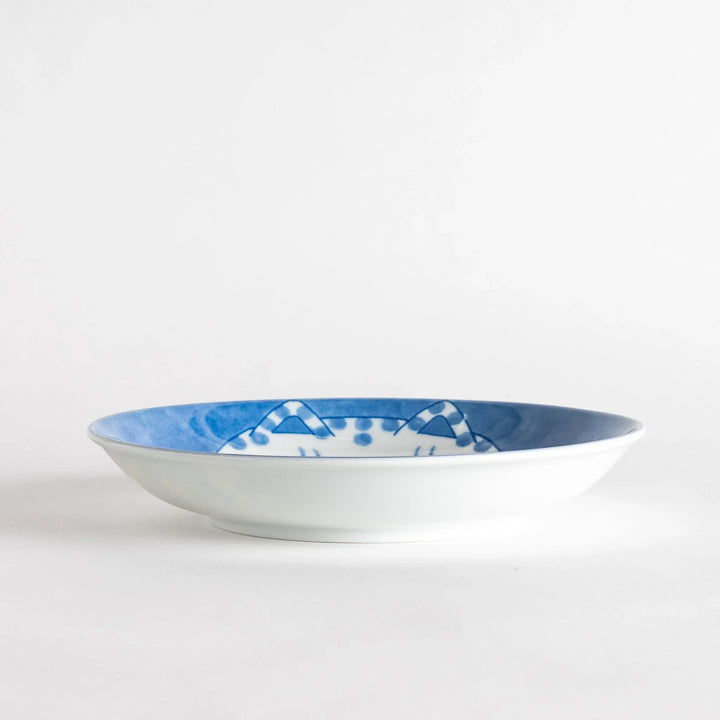 A salad plate featuring a chubby blue-spotted white cat with a contented expression.