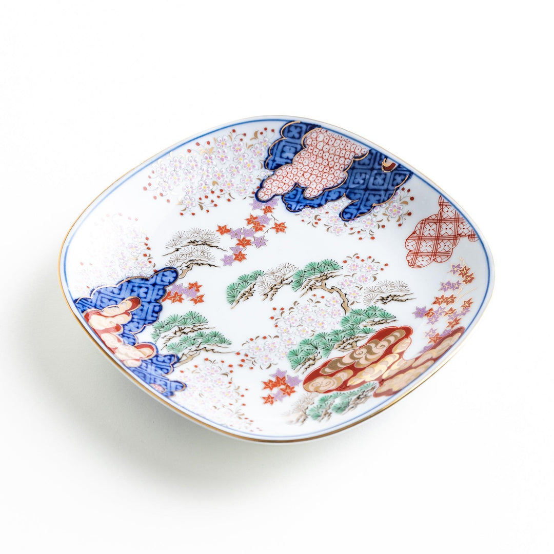 Square dessert plate with Japanese landscape design of trees and clouds bordered by red and blue patterns.