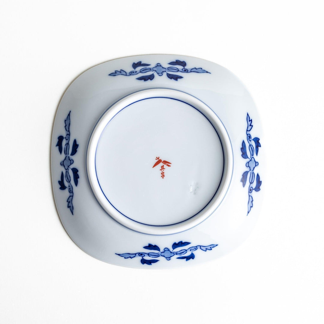 Square dessert plate with Japanese landscape design of trees and clouds bordered by red and blue patterns.