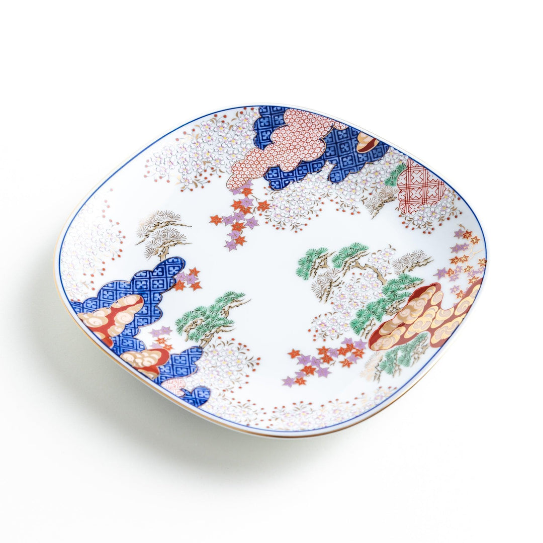 Square salad plate with Japanese landscape of trees clouds and maple leaves framed by blue red patterns.