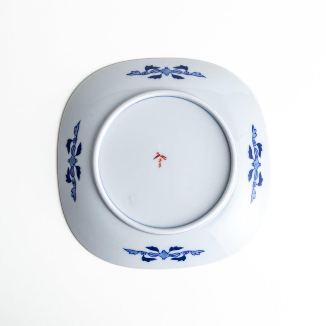 Square salad plate with Japanese landscape of trees clouds and maple leaves framed by blue red patterns.