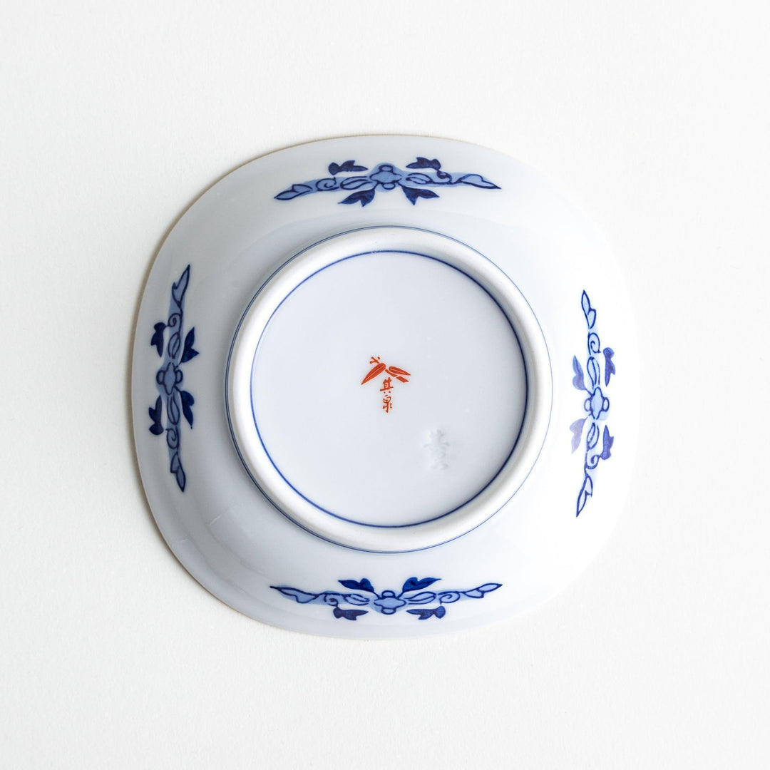 Square Japanese sauce dish with landscape trees clouds and golden sun bordered by blue and red patterns.