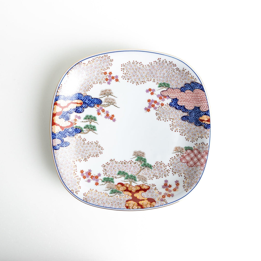 Square serving plate with white base featuring Japanese landscape of trees clouds and red maple leaves.