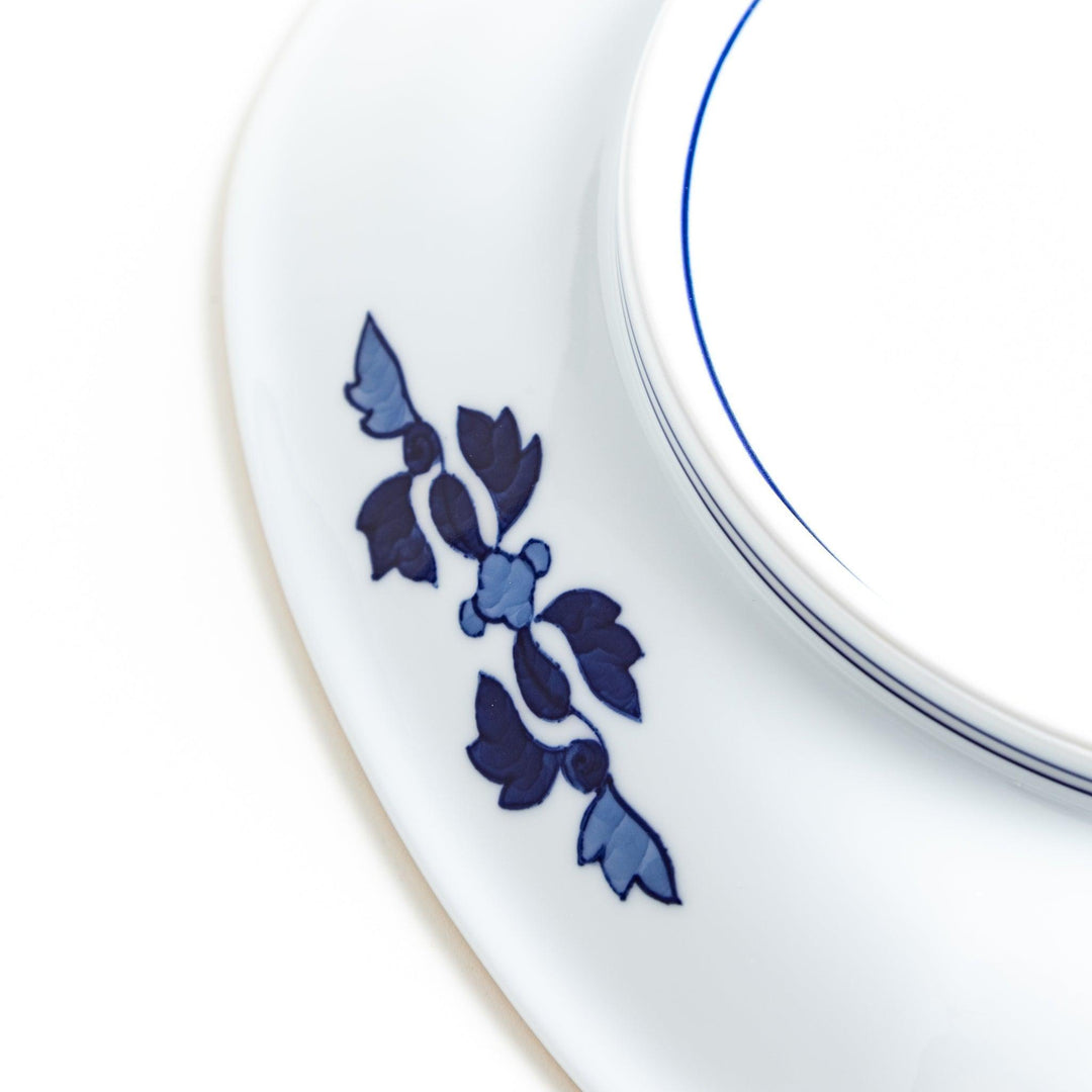 Square serving plate with white base featuring Japanese landscape of trees clouds and red maple leaves.