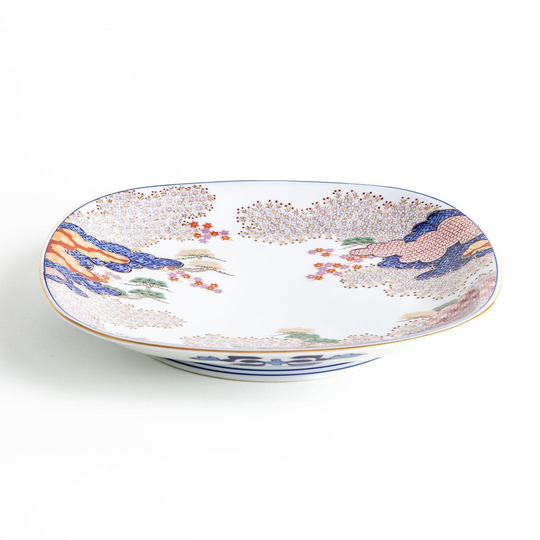 Square serving plate with white base featuring Japanese landscape of trees clouds and red maple leaves.