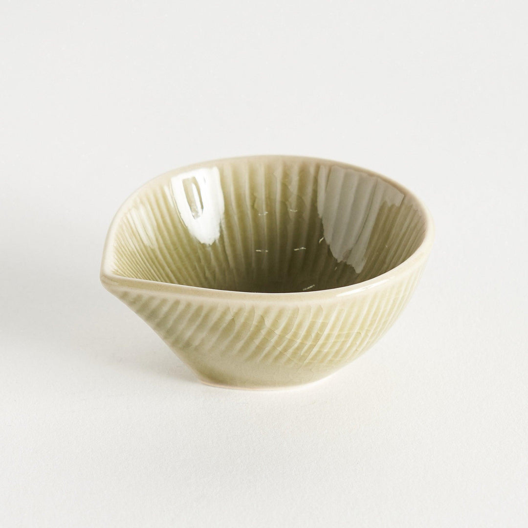 A small condiment bowl with a light green textured surface.