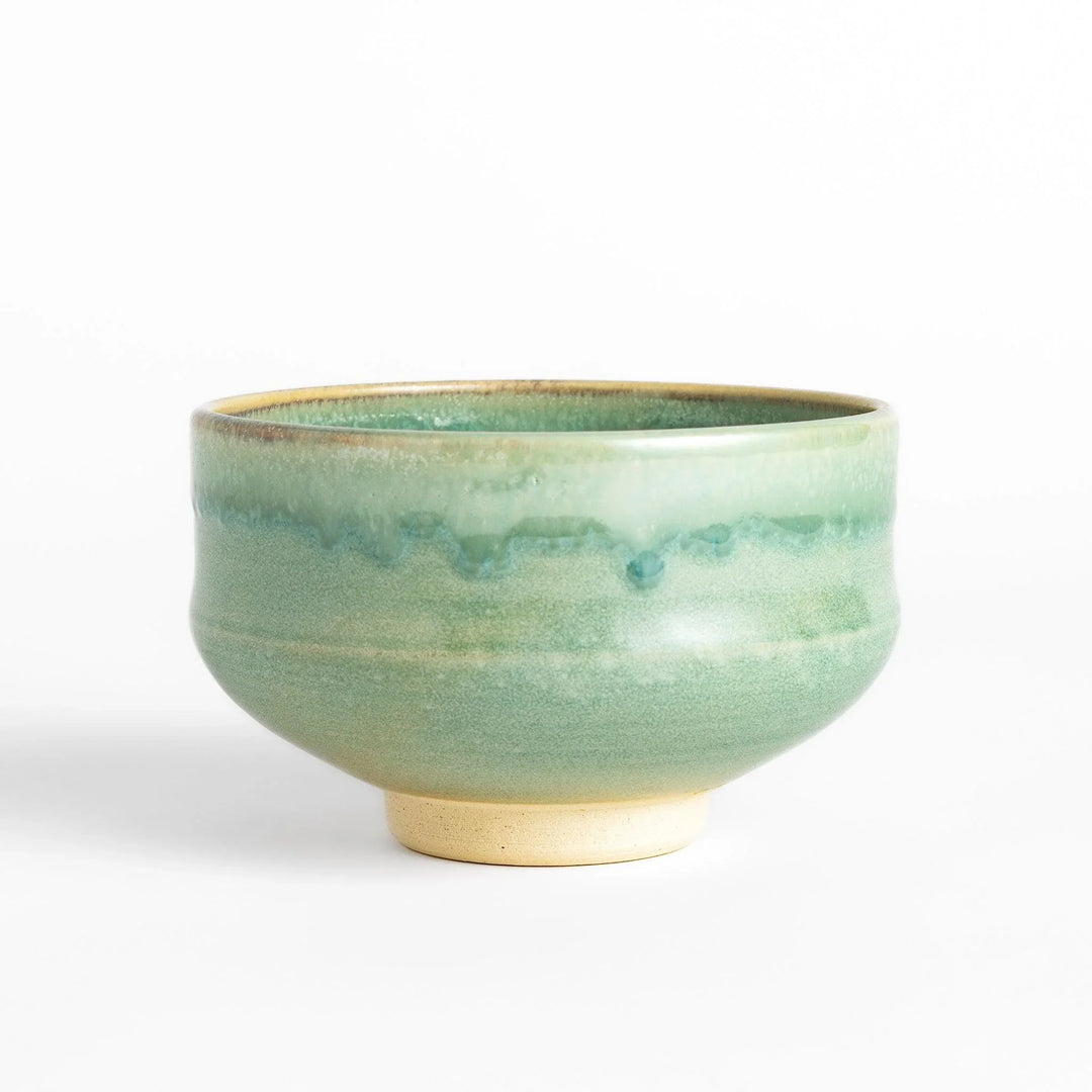 Green glazed ceramic matcha bowl with a rustic base, perfect for preparing and savoring matcha in a traditional tea ceremony.