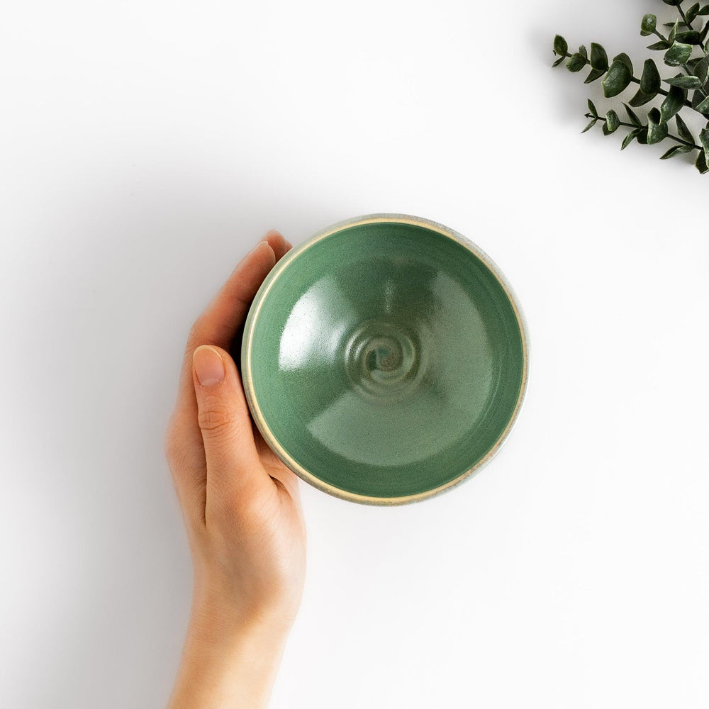Green glazed ceramic matcha bowl with a rustic base, perfect for preparing and savoring matcha in a traditional tea ceremony.