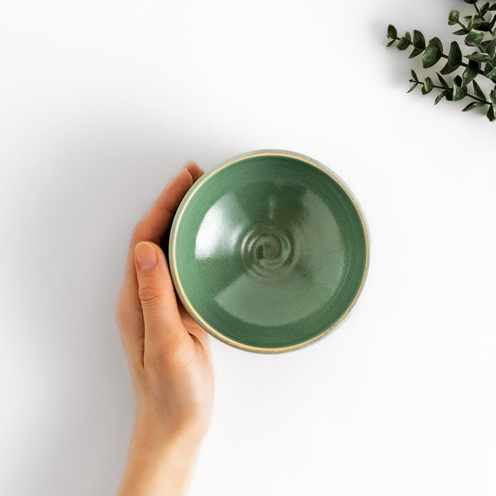 Green glazed ceramic matcha bowl with a rustic base, perfect for preparing and savoring matcha in a traditional tea ceremony.