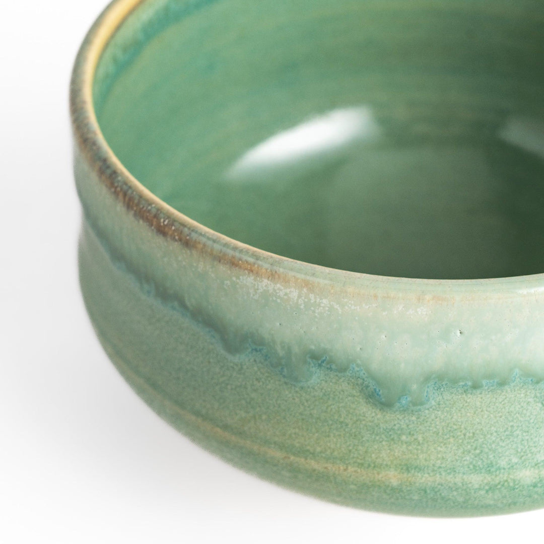 Green glazed ceramic matcha bowl with a rustic base, perfect for preparing and savoring matcha in a traditional tea ceremony.