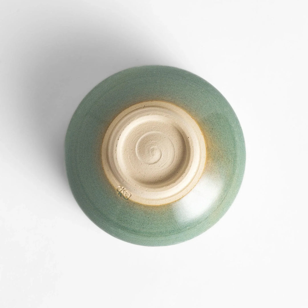 Green glazed ceramic matcha bowl with a rustic base, perfect for preparing and savoring matcha in a traditional tea ceremony.