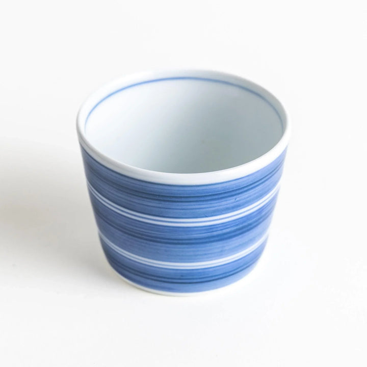 A small condiment bowl with horizontal blue or red stripes of varying shades, creating a minimalist yet elegant design.