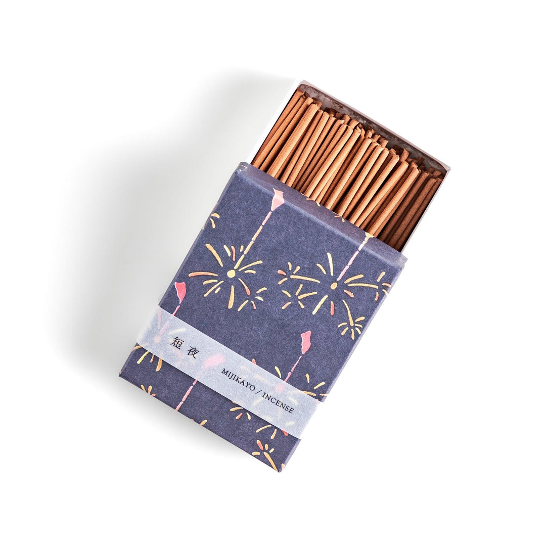 Japanese incense with brown sticks in dark blue box decorated with fireworks for soothing summer aroma.