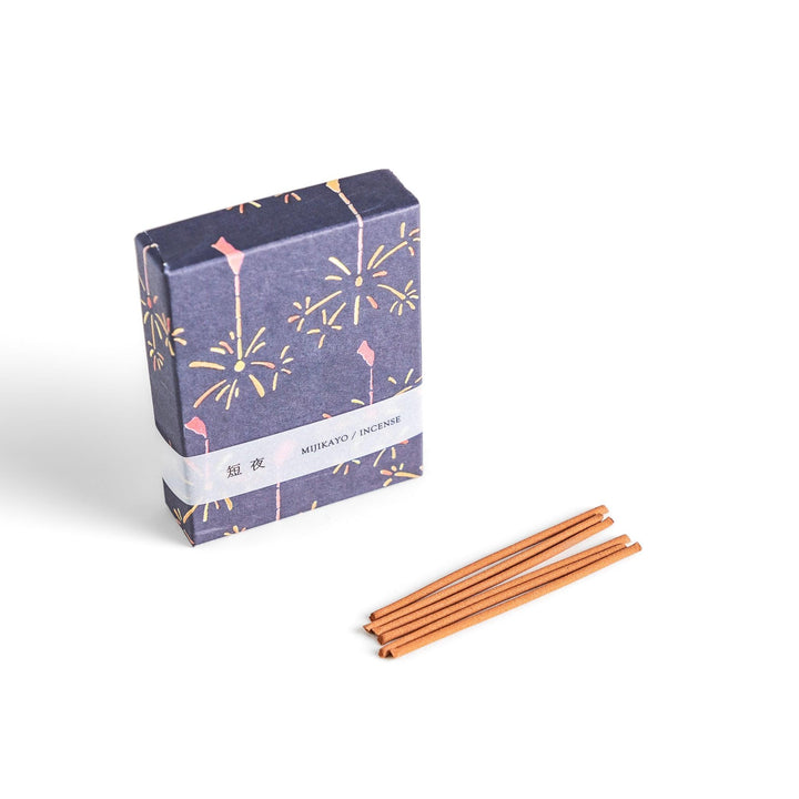 Japanese incense with brown sticks in dark blue box decorated with fireworks for soothing summer aroma.