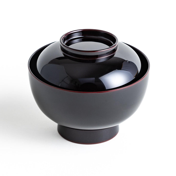 Traditional black lacquer bowl with red interior, featuring a gold pine tree design on the lid.