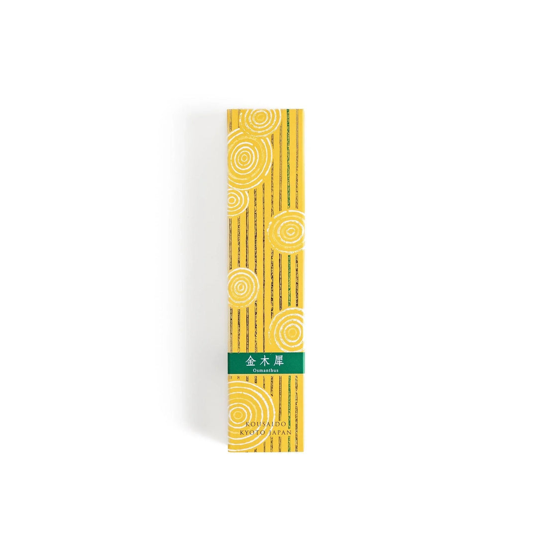 Japanese incense in wooden box with brown sticks and yellow design featuring white circle patterns.