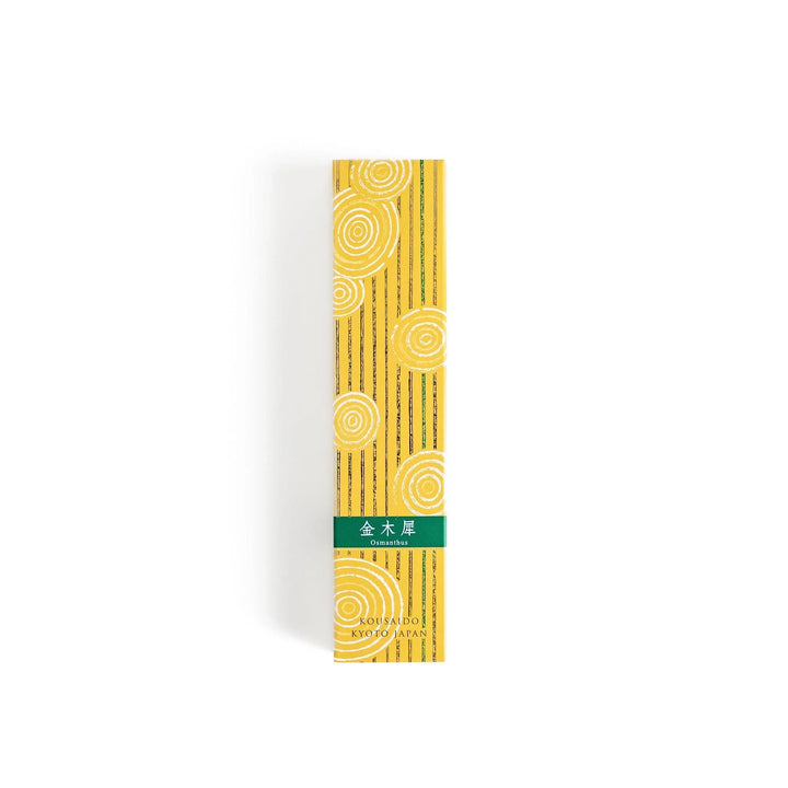 Japanese incense in wooden box with brown sticks and yellow design featuring white circle patterns.