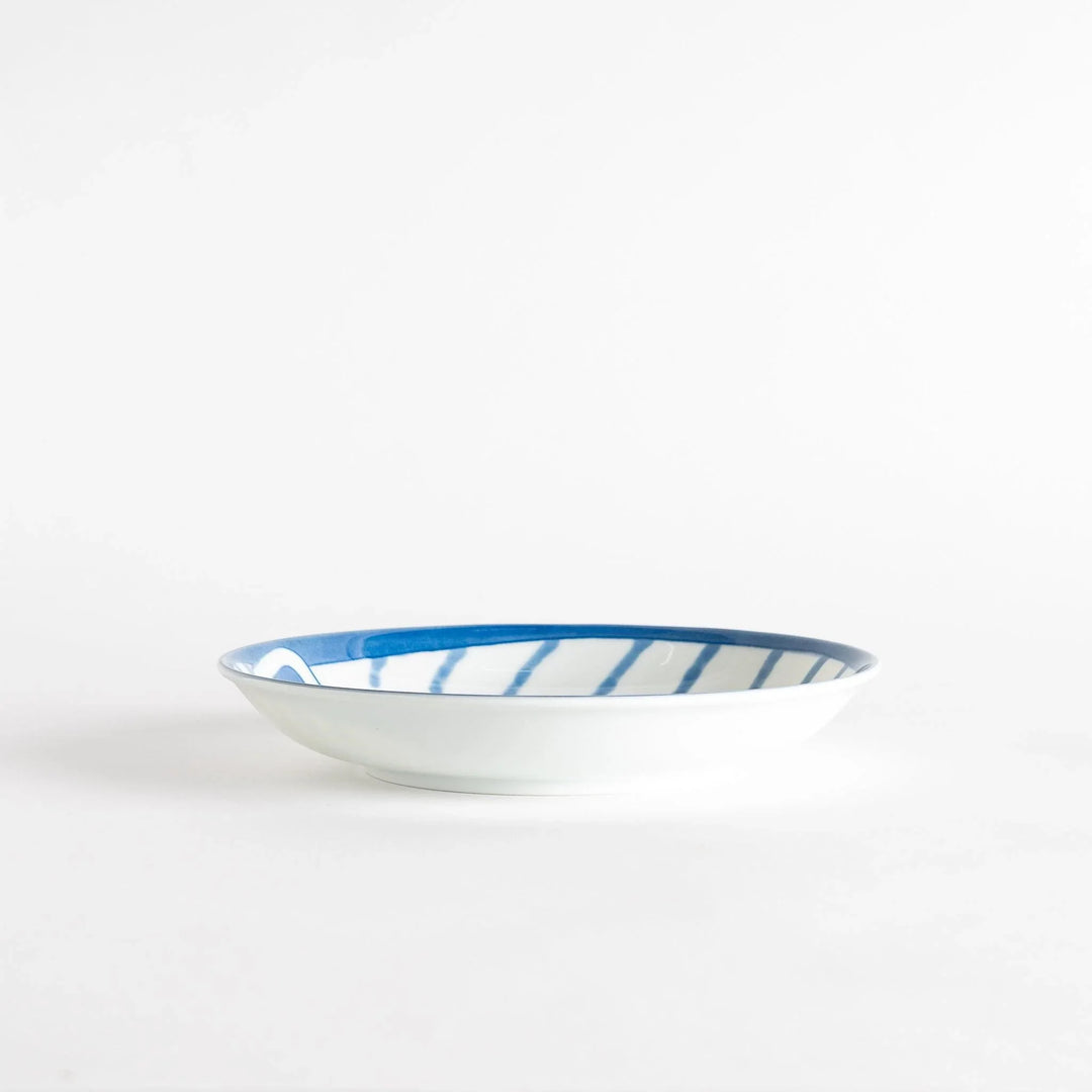 A salad plate with a blue-striped white cat, smiling with closed eyes.