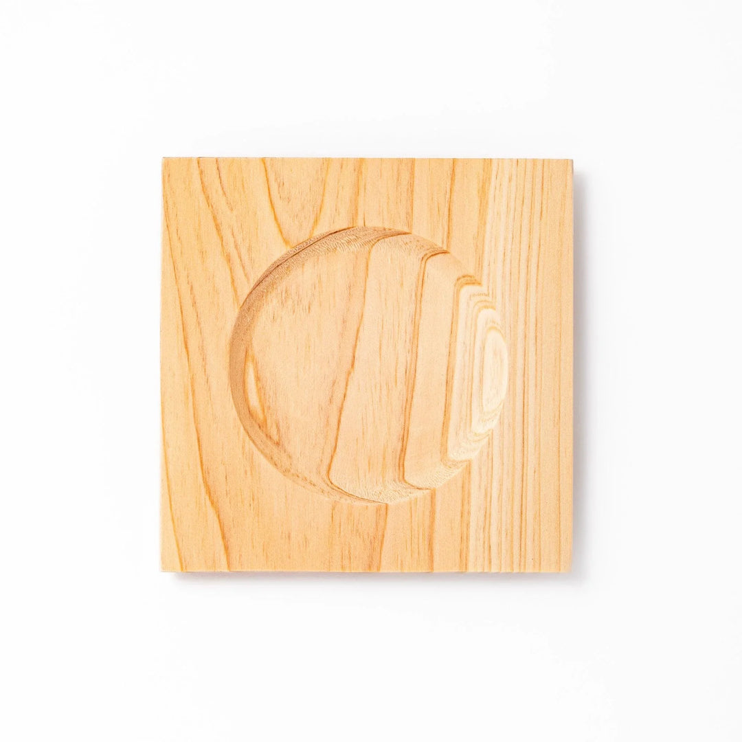 Square hinoki wood coaster with recessed circular center and beveled edge, featuring natural grain for elegant cup support.