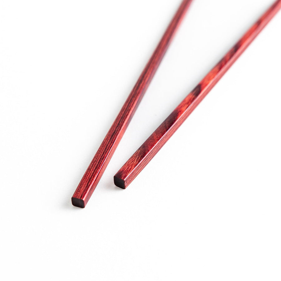 A pair of simple thin lacquered chopsticks with a minimalist design, perfect for everyday use. Available in red or black.