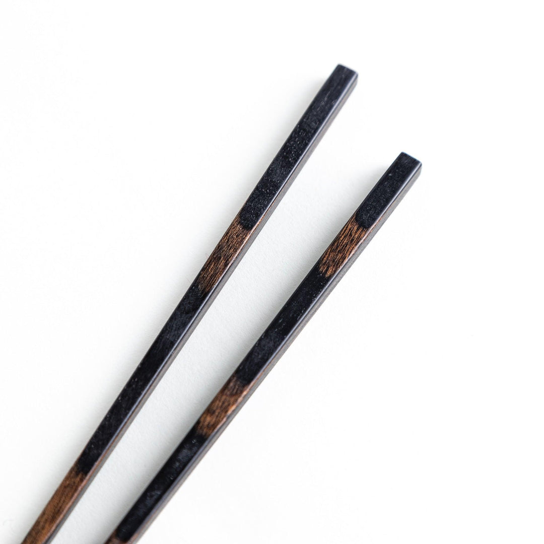 A pair of simple thin lacquered chopsticks with a minimalist design, perfect for everyday use. Available in red or black.