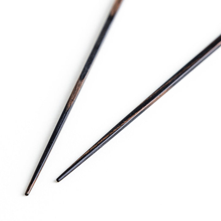 A pair of simple thin lacquered chopsticks with a minimalist design, perfect for everyday use. Available in red or black.