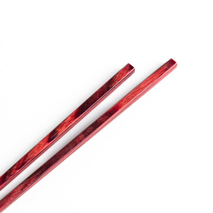A pair of simple thin lacquered chopsticks with a minimalist design, perfect for everyday use. Available in red or black.