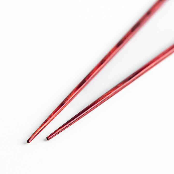 A pair of simple thin lacquered chopsticks with a minimalist design, perfect for everyday use. Available in red or black.