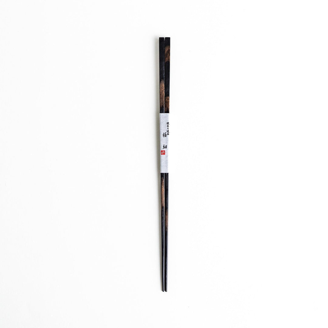 A pair of simple thin lacquered chopsticks with a minimalist design, perfect for everyday use. Available in red or black.