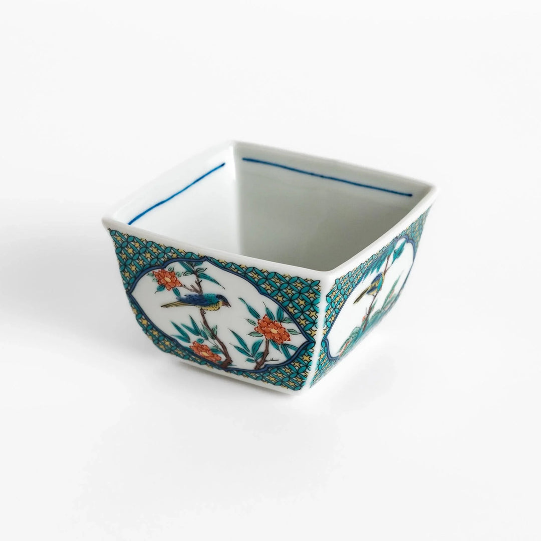 Traditional flower and bird design adorns this elegant condiment bowl, framed with intricate blue patterns.