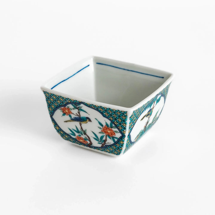 Traditional flower and bird design adorns this elegant condiment bowl, framed with intricate blue patterns.