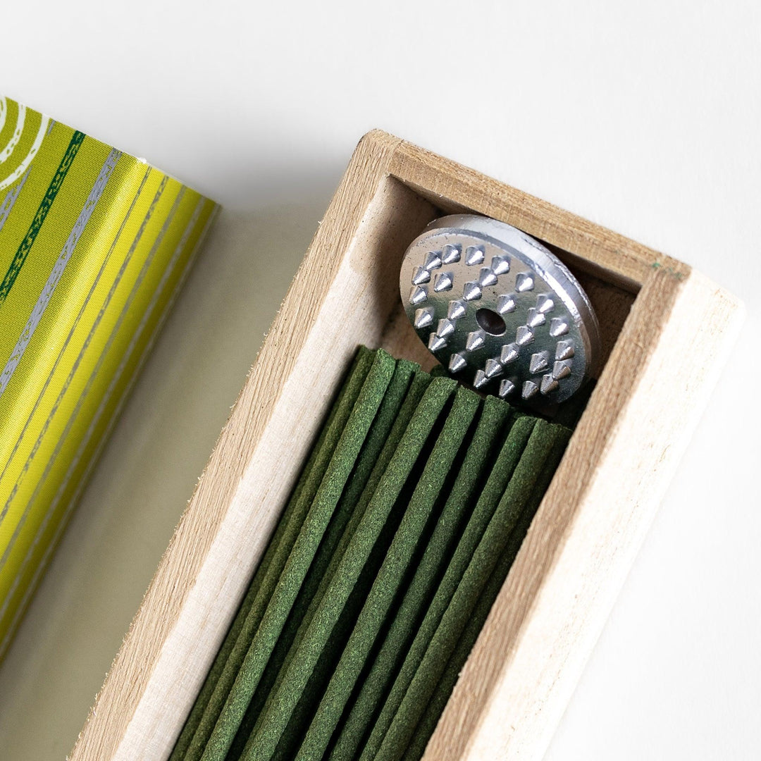 Japanese Green Tea incense sticks in a yellow patterned box with wooden holder, offering a fresh, soothing aroma from Kyoto