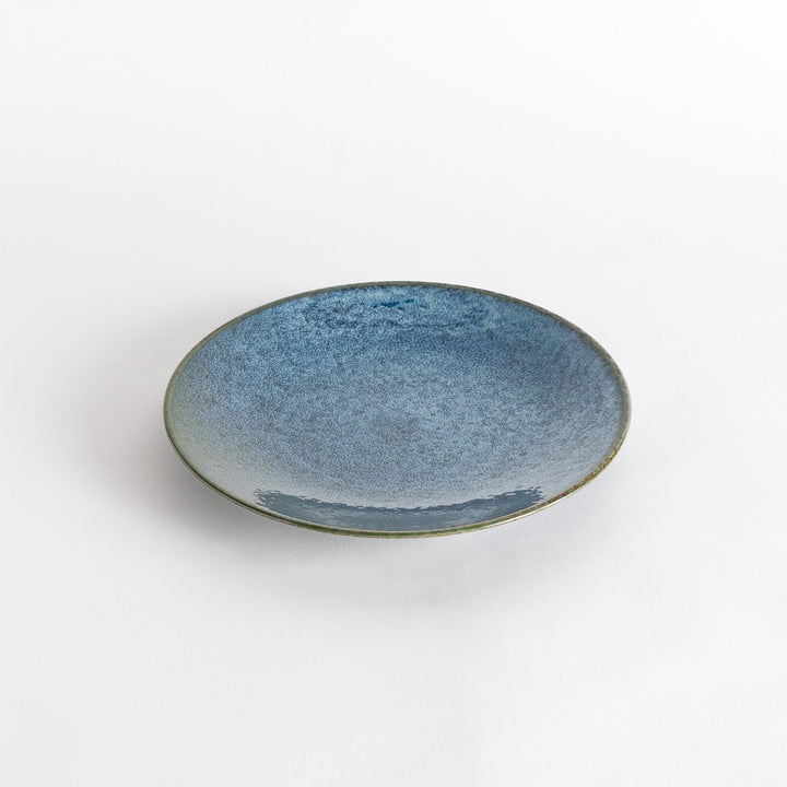 A round salad plate featuring a deep blue color and a fine speckled texture.