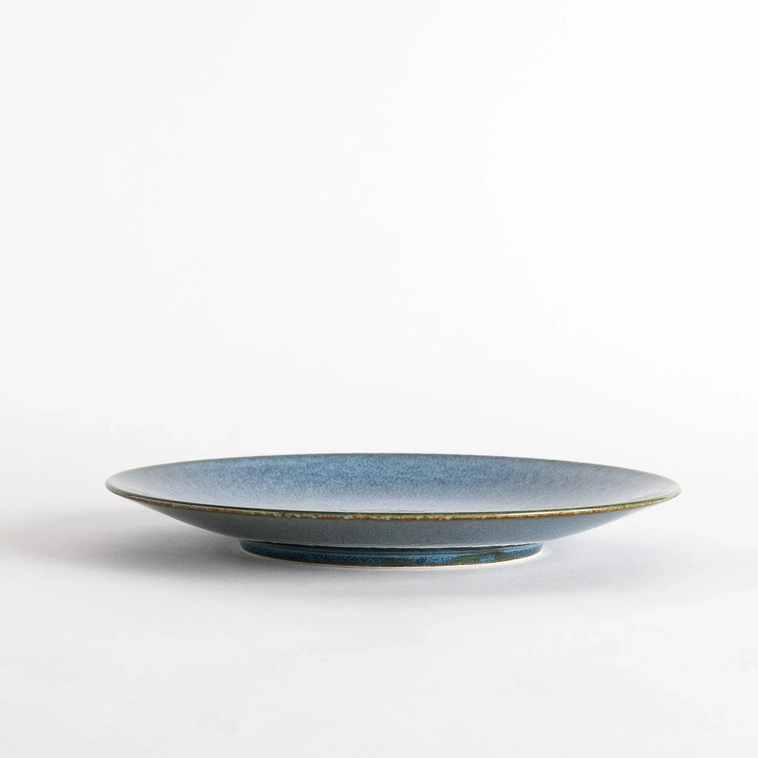 A round salad plate featuring a deep blue color and a fine speckled texture.