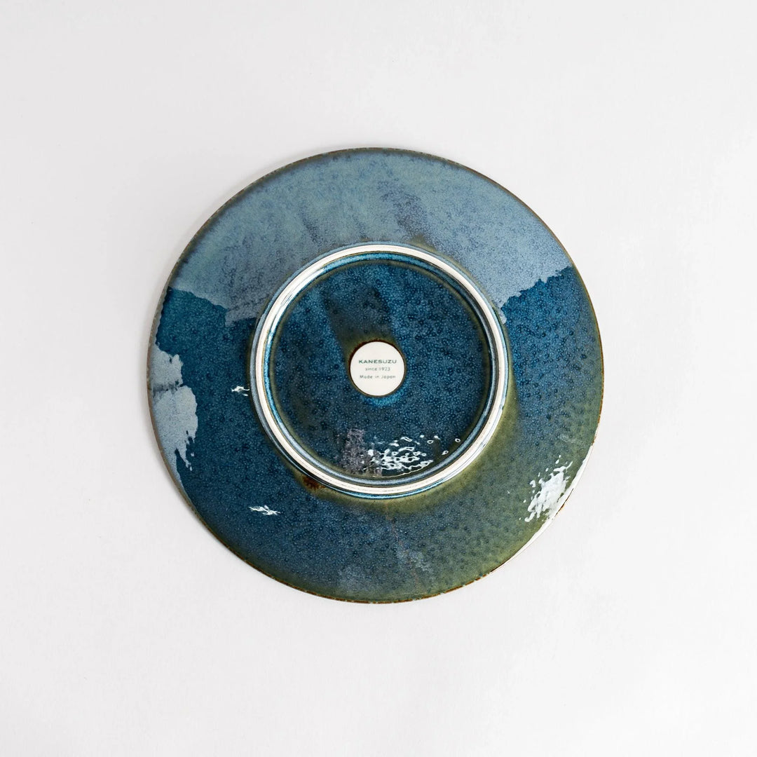 A round salad plate featuring a deep blue color and a fine speckled texture.