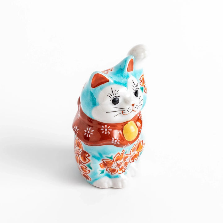 Turkish blue Japanese Maneki Neko figurine with floral patterns golden bell and raised paw for good fortune.