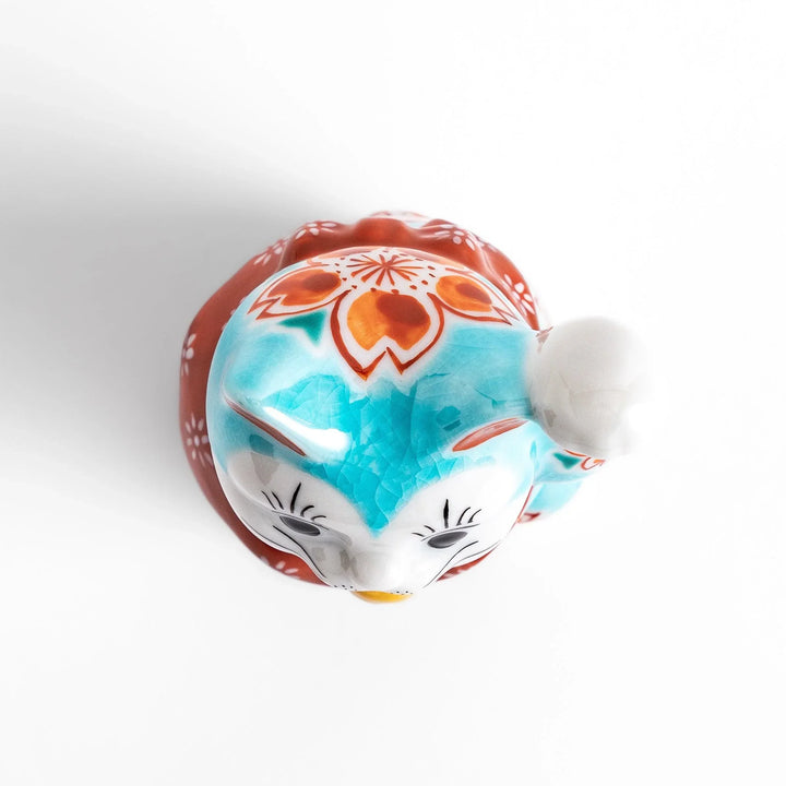 Turkish blue Japanese Maneki Neko figurine with floral patterns golden bell and raised paw for good fortune.