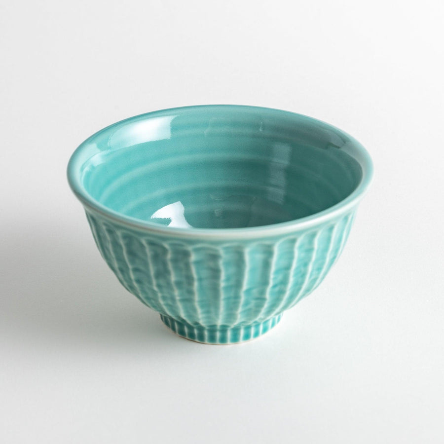 A light turquoise ceramic rice bowl with a natural, rustic texture and a ribbed design.