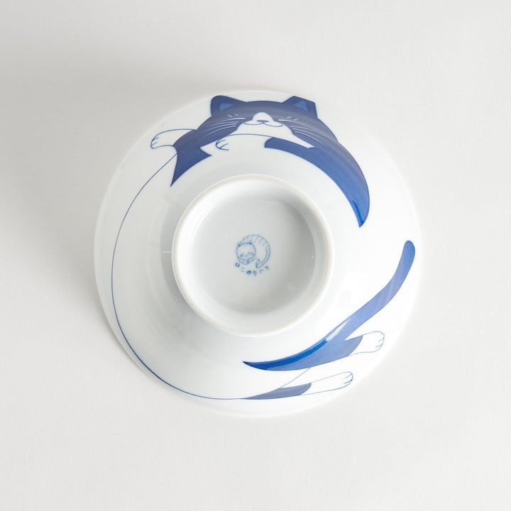 A white ramen bowl featuring a playful blue cat lying down with its eyes closed.