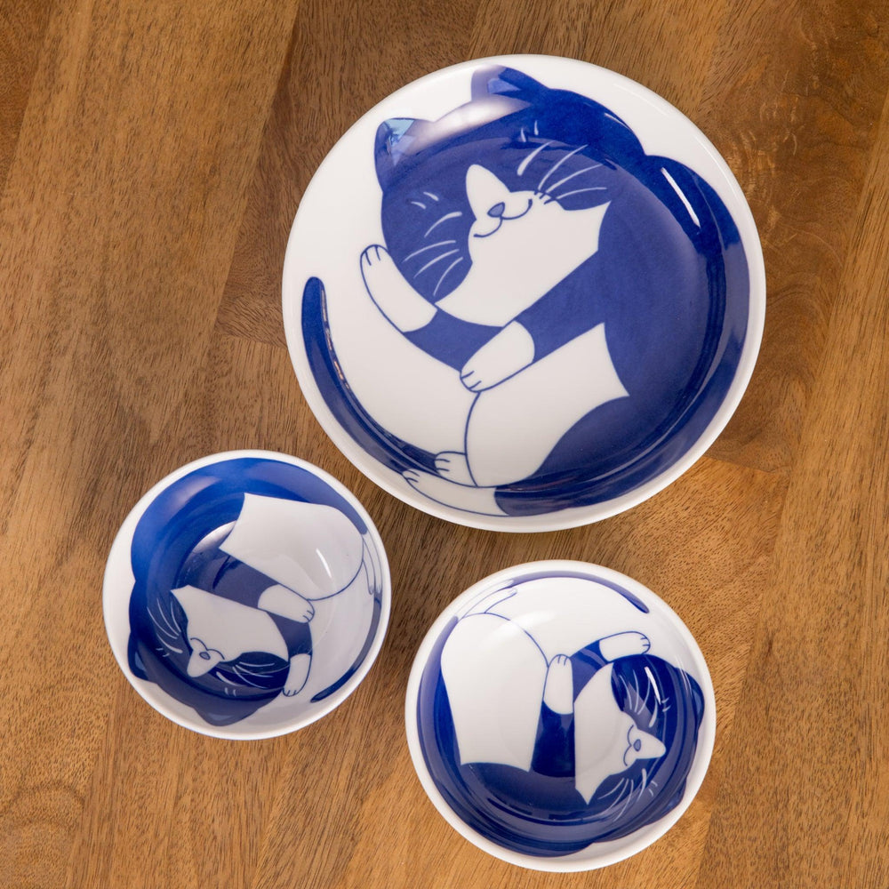 White sauce dish with a blue chrysanthemum mesh pattern and scalloped edges.