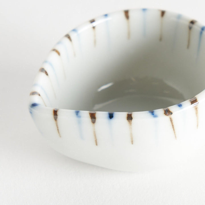 A small, curved condiment bowl featuring vertical blue and brown stripes.