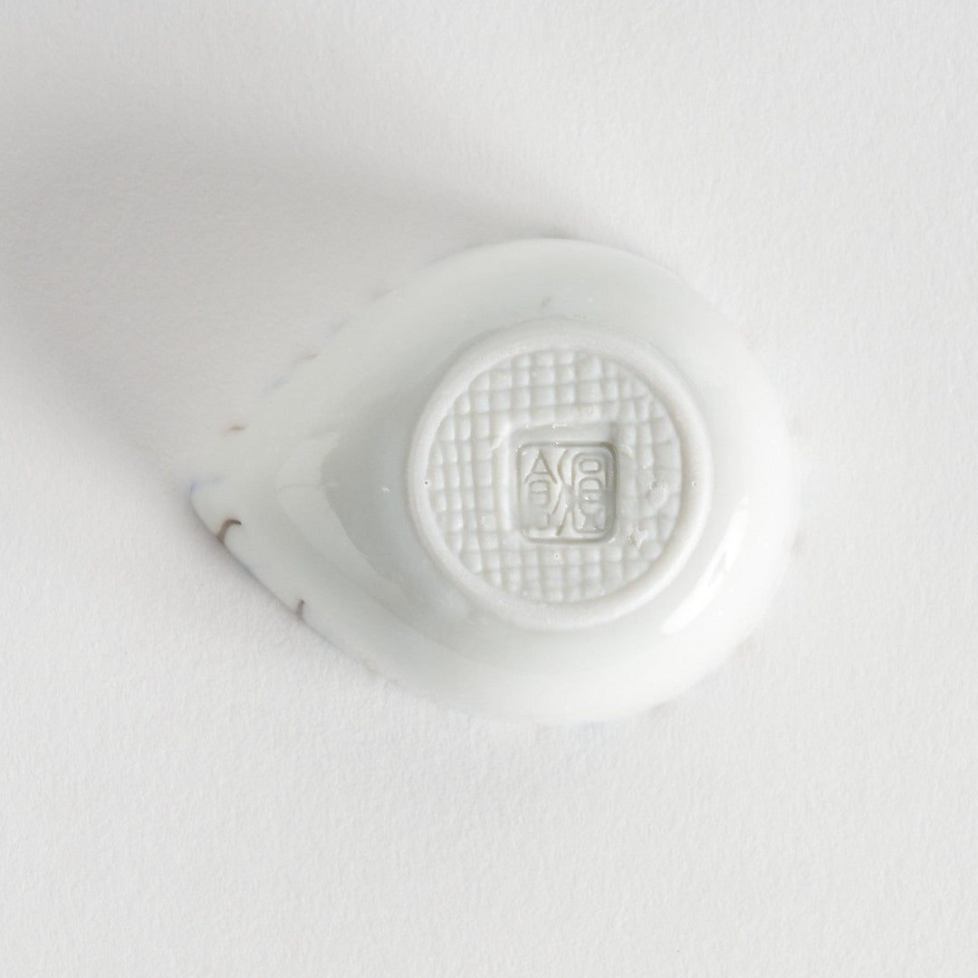 A small, curved condiment bowl featuring vertical blue and brown stripes.