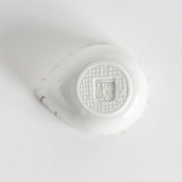 A small, curved condiment bowl featuring vertical blue and brown stripes.